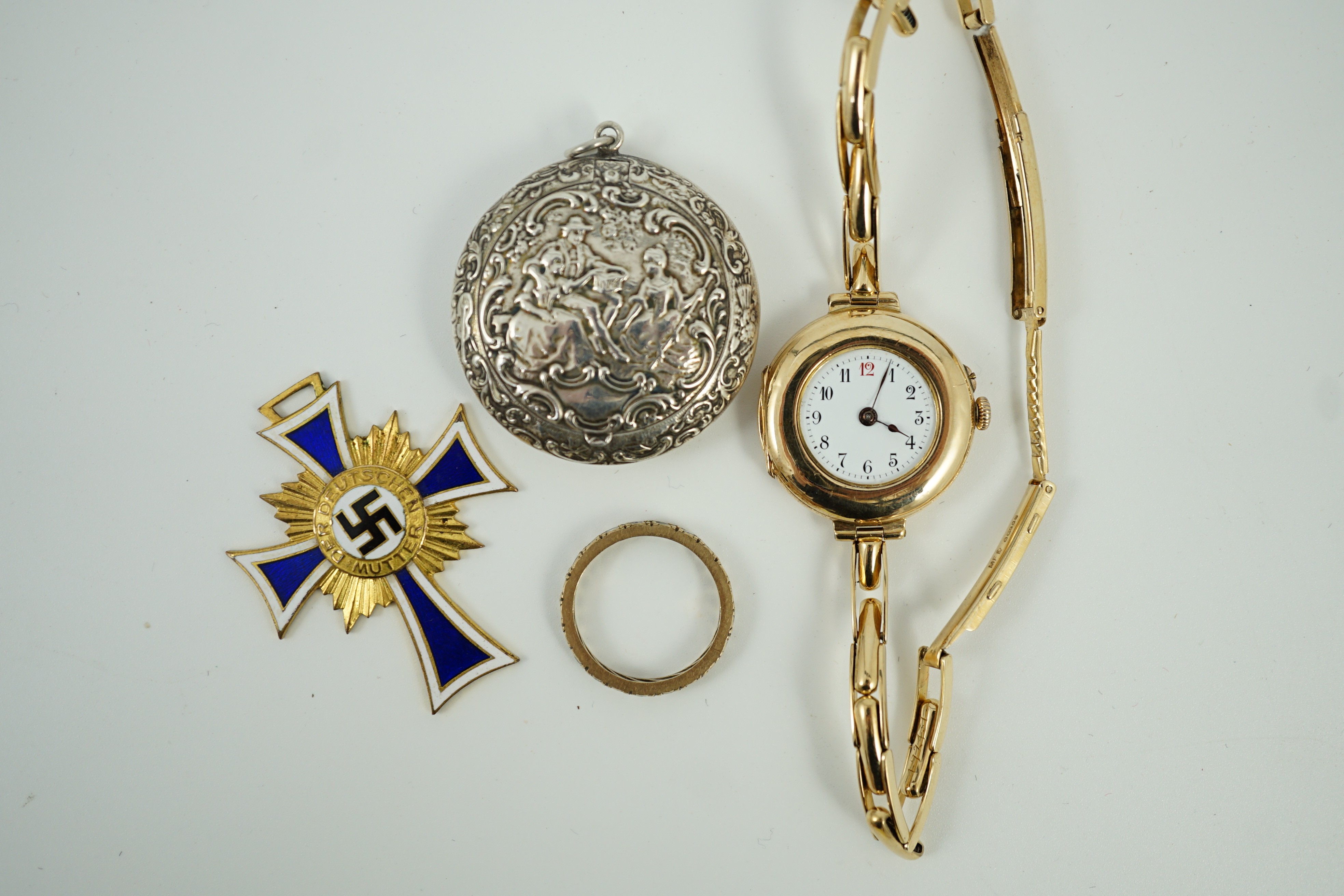 An early 20th century 9ct gold manual wind wrist watch, on a 15ct expanding bracelet, case diameter 28mm, gross weight 25.3 grams, a yellow metal and simulated diamond set eternity ring, A 1930's German git and enamel cr